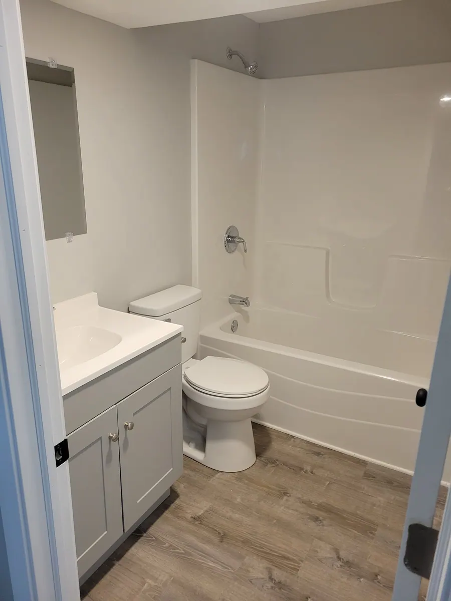 Two-bedroom unit bathroom with vanity, toilet and bathtub