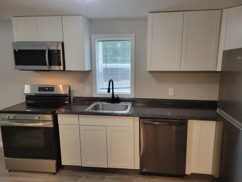 Two-bedroom unit kitchen with white cabinets and stainless-steel appliances