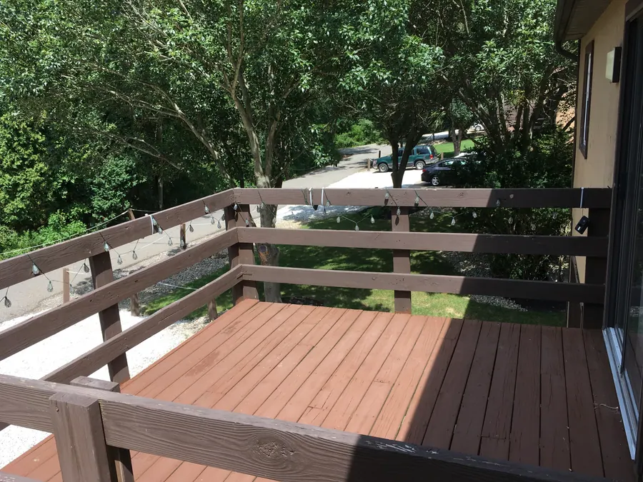 Wooden townhome balcony looking onto the tree-lined drive